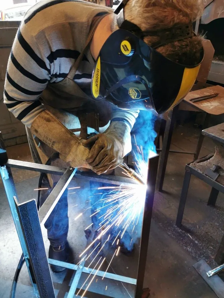 Welding Geordi's frame together, sparks and blue smoke coming off the weld